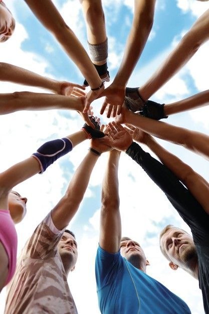 A group of people in a circle joining hands together